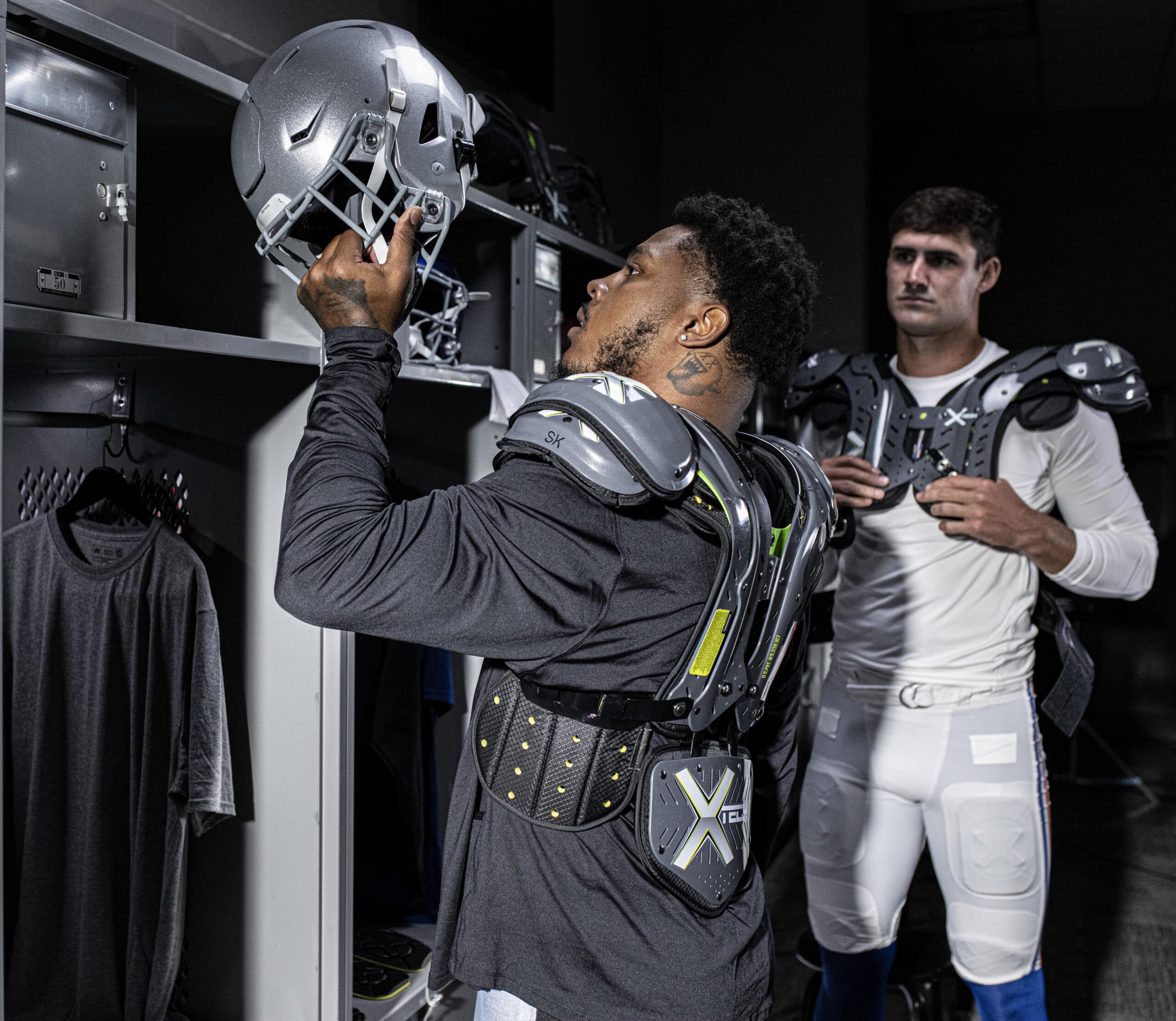 Football player wearing XTECH 5-sided backplate in a locker room