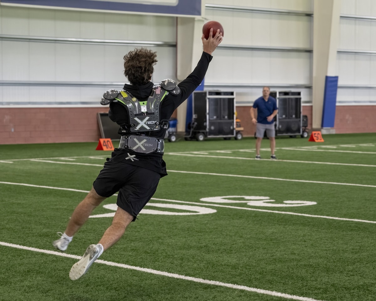 XTECH football player wearing shoulder pads during fit and sizing review.