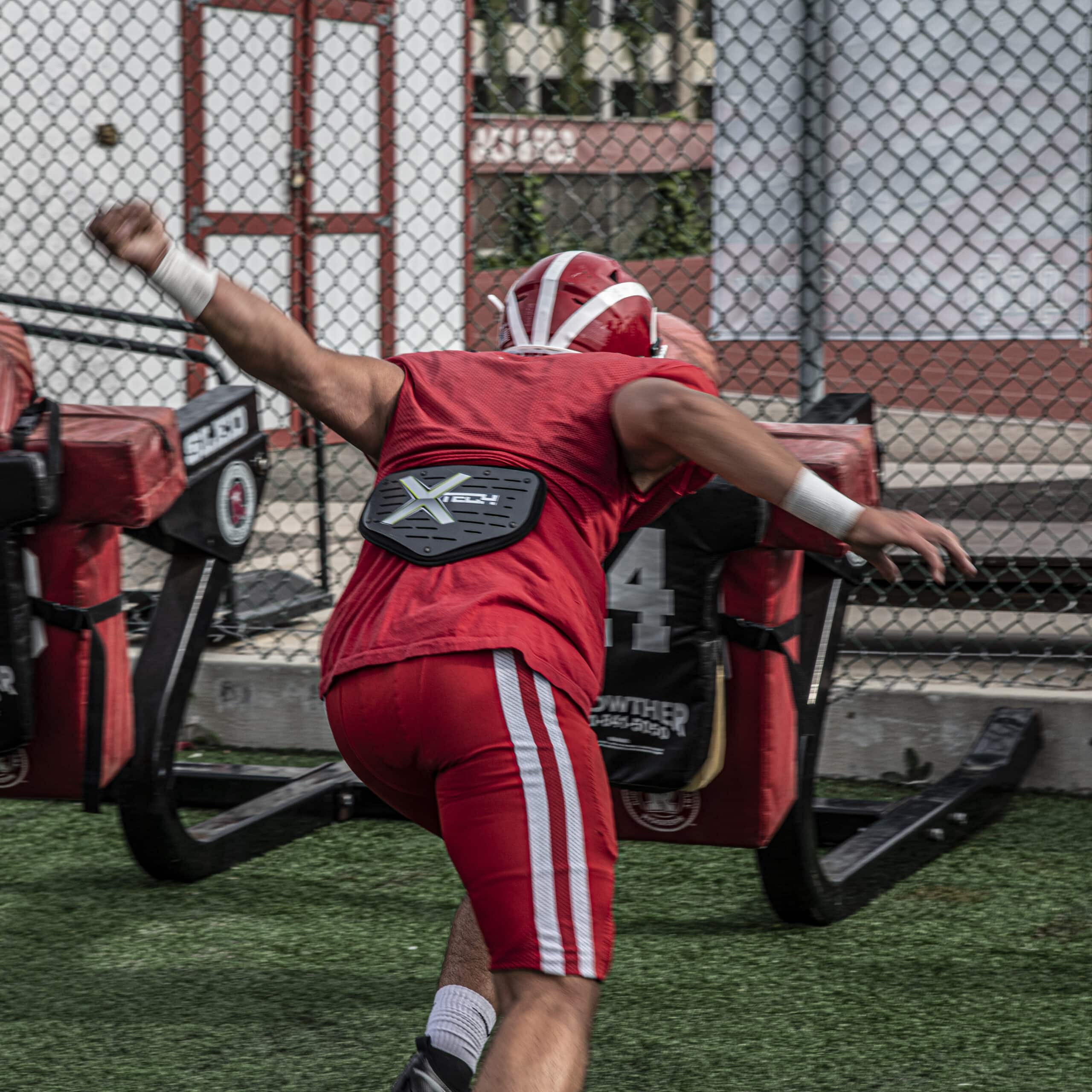 Football player wearing XTECH 5-sided backplate on shoulder pads from the rear